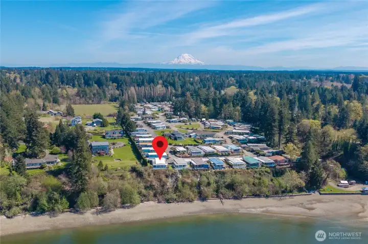 Pacific Northwest living at its finest—this aerial view captures the coastal setting with Puget Sound in the foreground and Mount Rainier visible in the distance.
