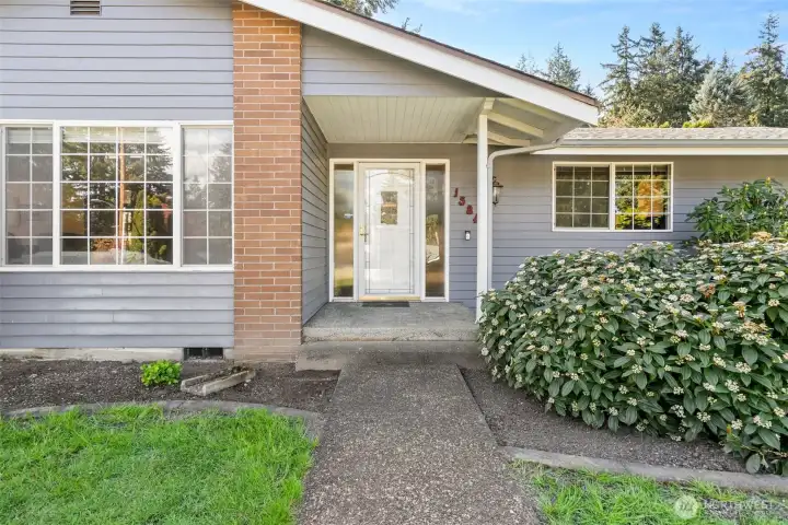 Side lights at the front door plus a storm door make for a lovely entry