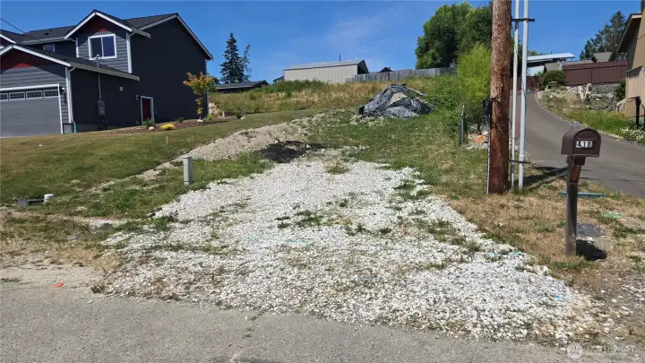 roughed in driveway for buyer to finish, extra dirt on site.
