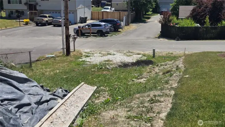 Driveway looking down at street for buyer to finish grade with extra dirt on site