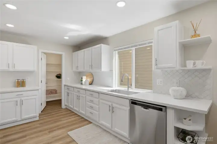 Crisp white cabinetry creates a timeless look and designer backsplash and lighting.  a huge walk in closet!