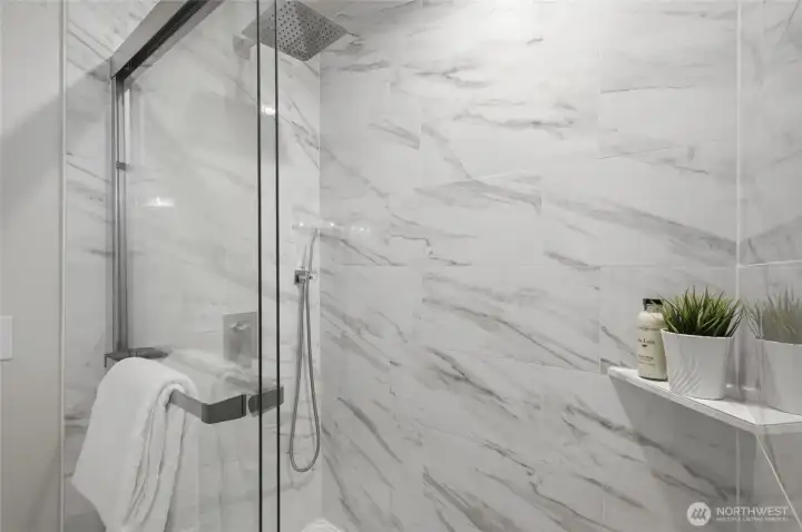 Tile wrapped large shower with dual shower heads create a luxurious experience.