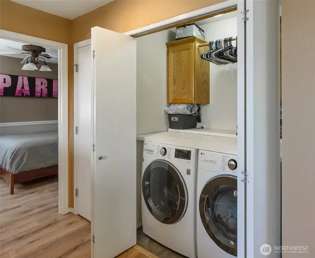 Upper floor laundry with newer washer and dryer.  To the left, a linen closet.