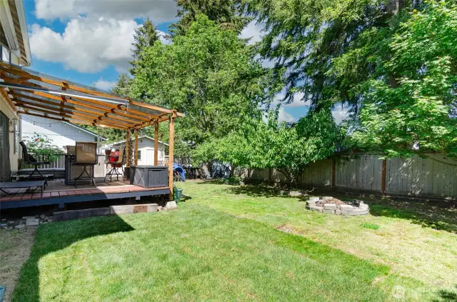 Side view of the back yard.  Fire pit to the right.