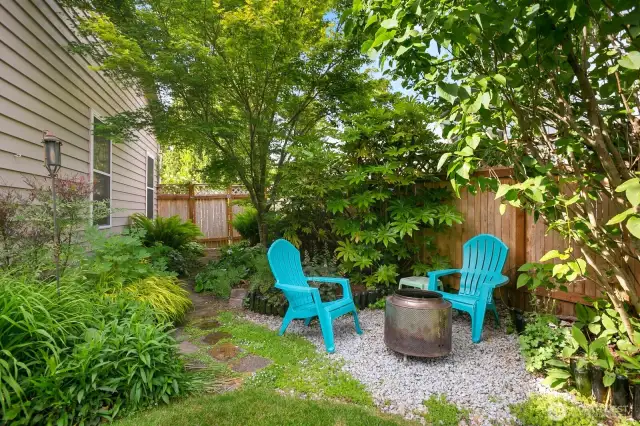 Tucked-away fire pit area surrounded by lush plantings—a peaceful retreat for evening gatherings.