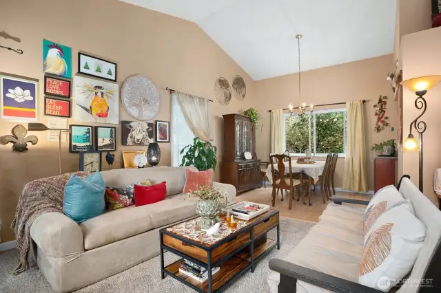 Light-filled living room with vaulted ceilings, large windows, and cozy.