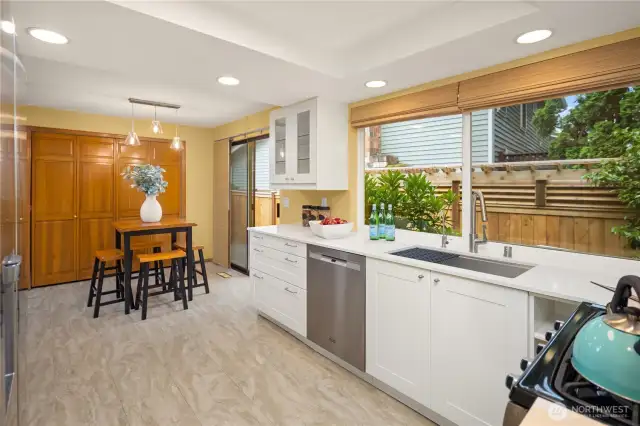 Bright white cabinetry and quartz counter tops grace the nicely updated kitchen, complete with gas stove.  Paved patio on this side of the yard too, fully fenced!