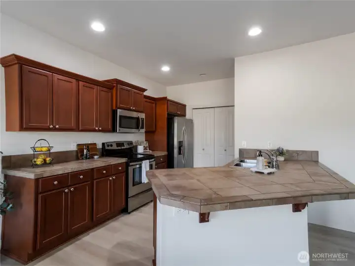 Kitchen features tile countertops, stainless steel appliances, smooth top range, cabinets with crown molding & pull-out shelves, pantry & breakfast bar...gas is available.