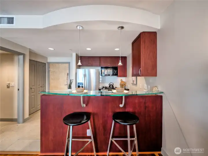 Sleek cabinetry and a curved bar create a perfect spot for casual dining