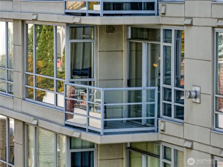 Modern urban elegance with private balcony and floor-to-ceiling windows.