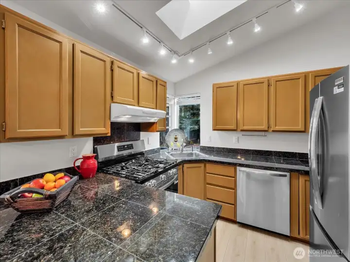 Kitchen with new appliances, granite countertops and new LVP flooring.