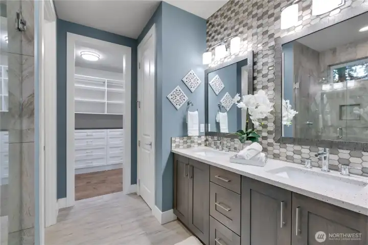 Oversized tiled shower, in mirror reflection; extended dual vanity; separate toilet room to left; linen closet to right of Walk In Closet. Storage galore!