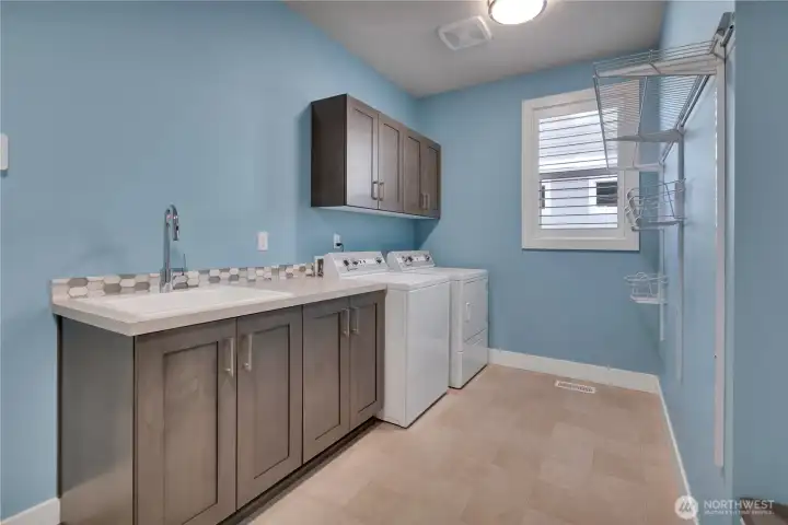 A laundry/mud room to show off!  Garage access is to the left; Great Room to the right.  Speed Queen Commercial washer and dry stay!! Note laundry sink, storage & counter space.