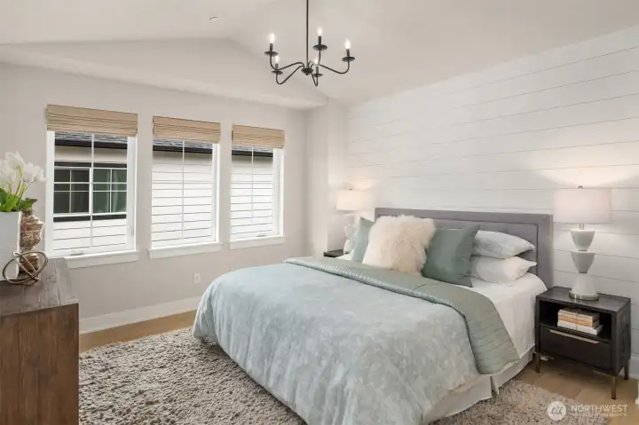 Primary bedroom retreat offering peaceful natural light and a comfortable, private setting with motorized blinds.