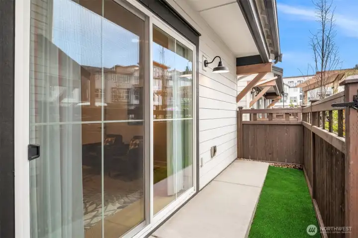 Private patio with sliding glass doors creating seamless indoor-outdoor flow.