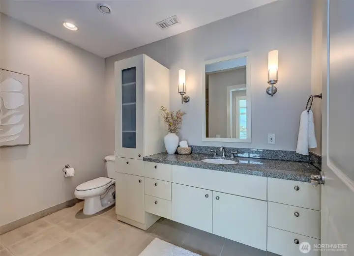 Second bath off of the guest bedroom offers convenience and loads of storage space.