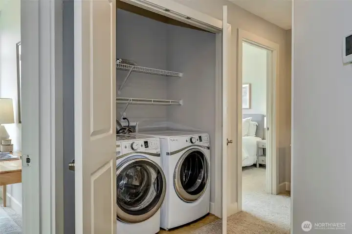 Laundry with full size washer and dryer plus storage.