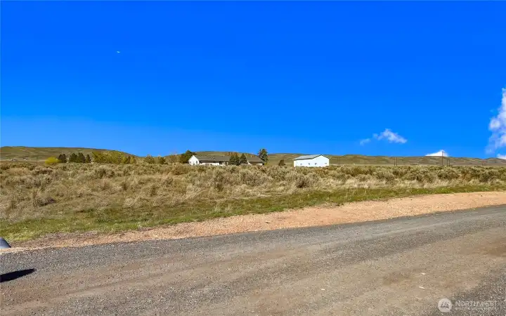 South West corner of the property, lot lines are approximately the fence line on other side of driveway.