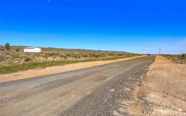 View from South West corner of property looking down driveway and fence line.