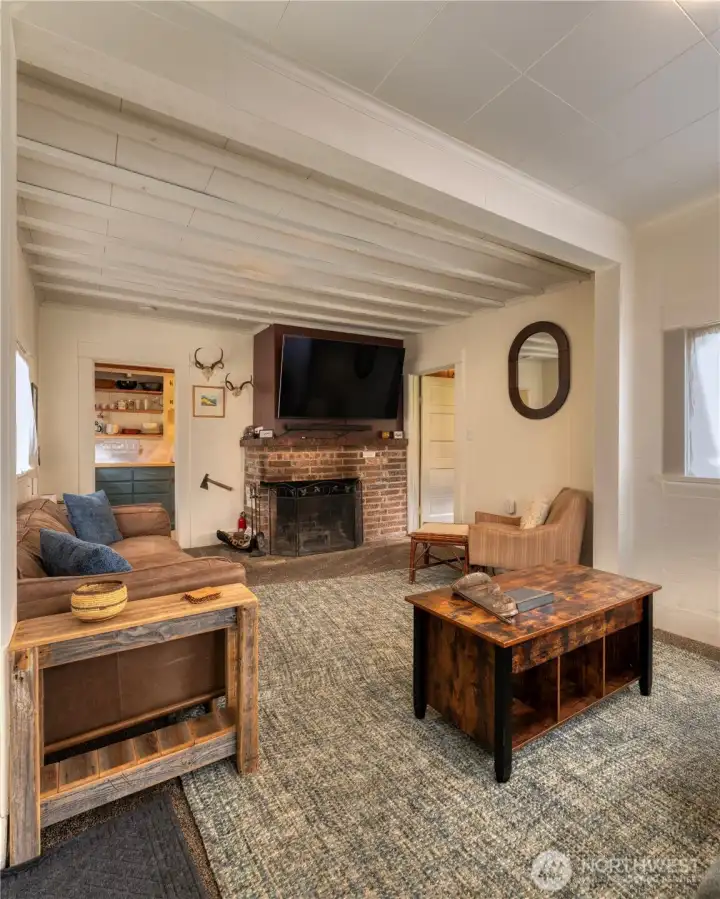 A classic brick fireplace serves as a timeless focal point adding warmth & ambiance to the living area. 60" TV, wall mount and sound bar included.