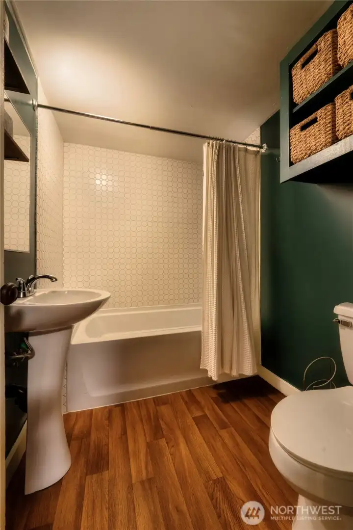 Updated full bath featuring tile work and convenient built-in storage.