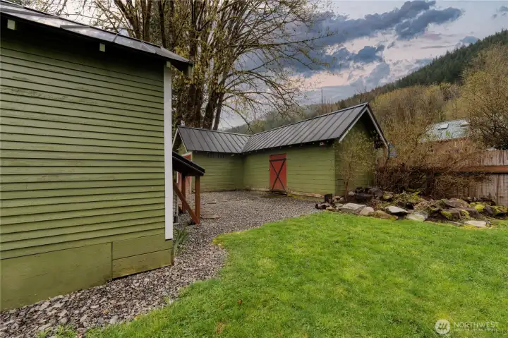 Low maintenance yard with easy care perennials. Wildflowers were recently added on the edge of the property, for colorful enjoyment this summer.  Door pictured leads to a sizeable workshop area or storage.