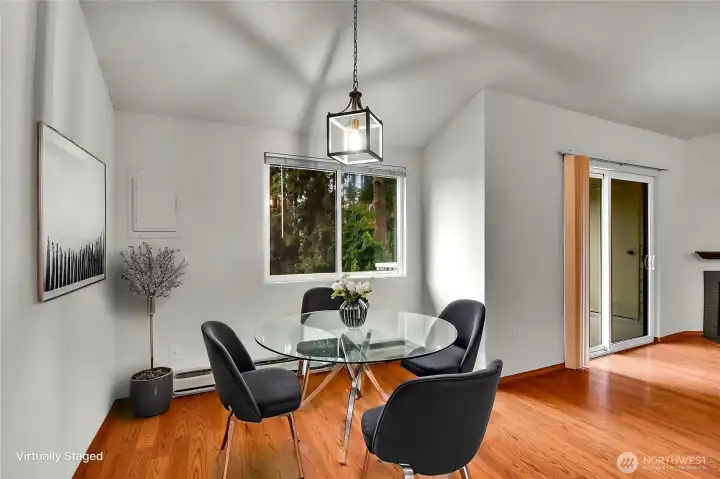 Dining area with vaulted ceilings and tranquil views of the surrounding trees. Virtually staged.