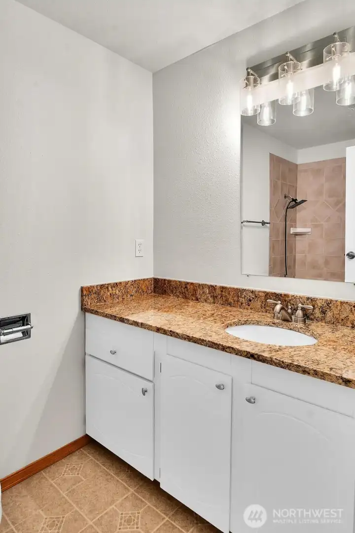 Full guest bathroom featuring granite countertops and a tile surround in the shower/bath..