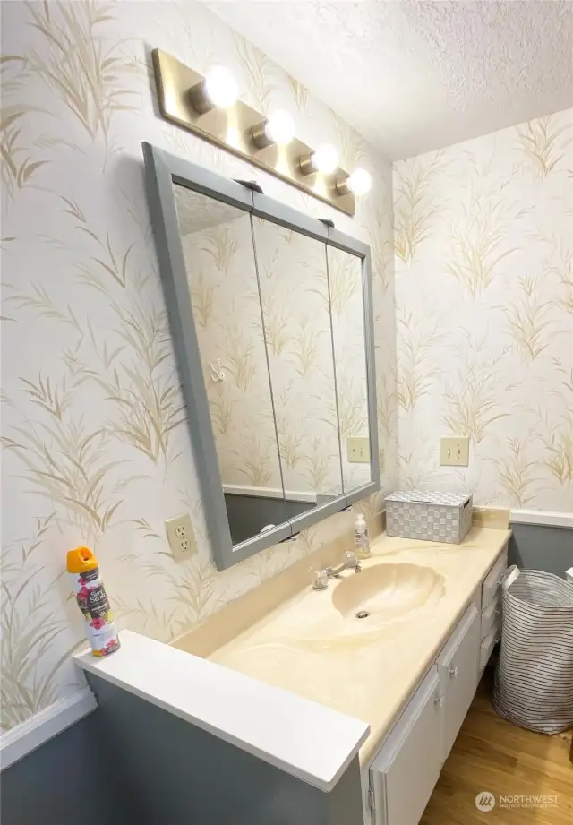 Additional bathroom with tub/shower. Soft wallpaper compliments and celebrates the beauty of nature and invokes a reflective and meditative  state of mind.