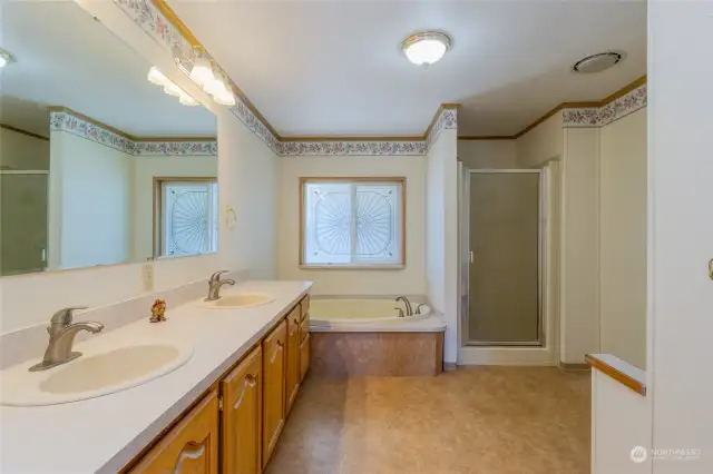 Primary en-suite bathroom features a double vanity, soaking tub and separate shower