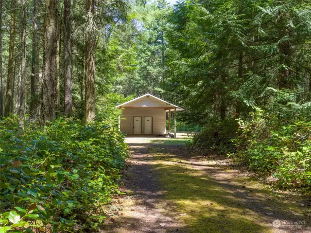 A summer driveway meanders into this level 10 acres with carport and shower/storage building attached.