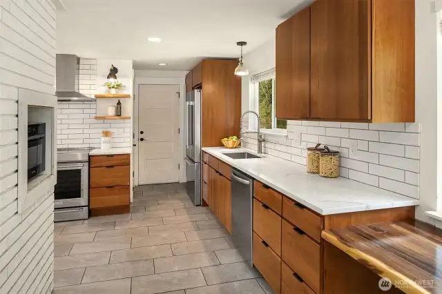Door to the carport for easy loading and unloading. Live edge desk in the kitchen at the heart of the home.