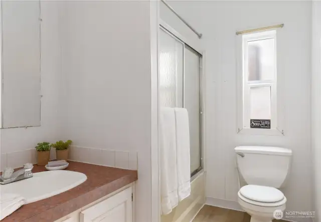 Main hall bath with full shower and tub.  New flooring and paint