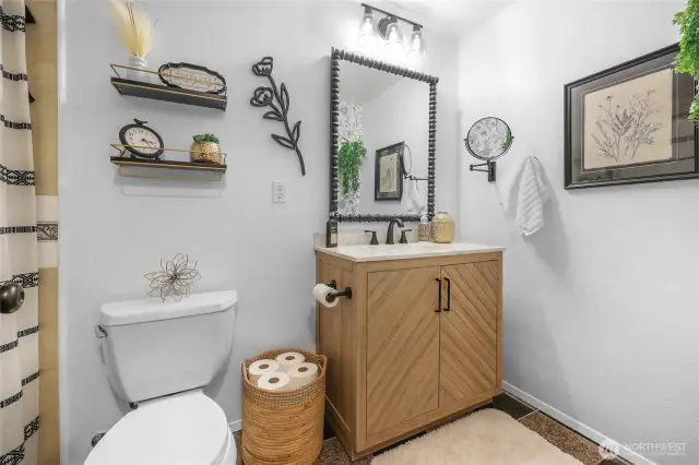 Upstairs Bathroom – Rustic-modern vanity with framed mirror and designer lighting for a cozy spa feel.
