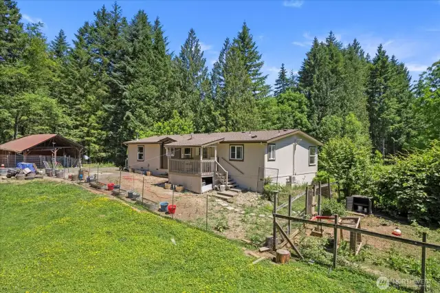 Front yard with covered deck and fencing for animals