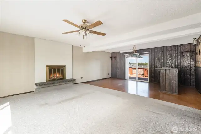 Spacious downstairs family room featuring a cozy fireplace & bar, perfect for gatherings and relaxation.