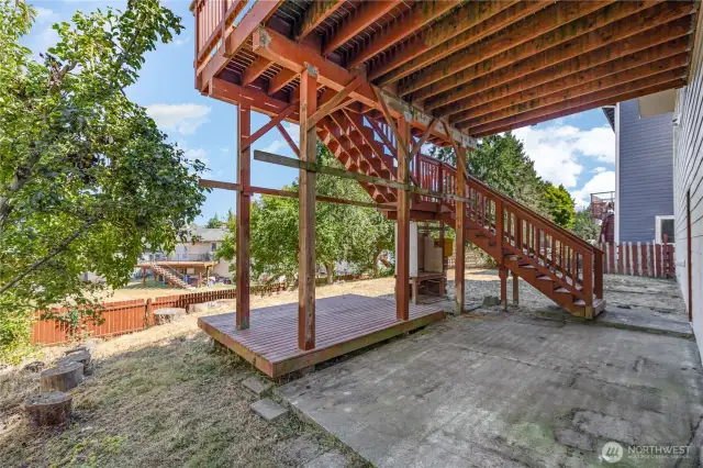 Cozy covered patio nestled beneath the deck, perfect for relaxing outdoors.