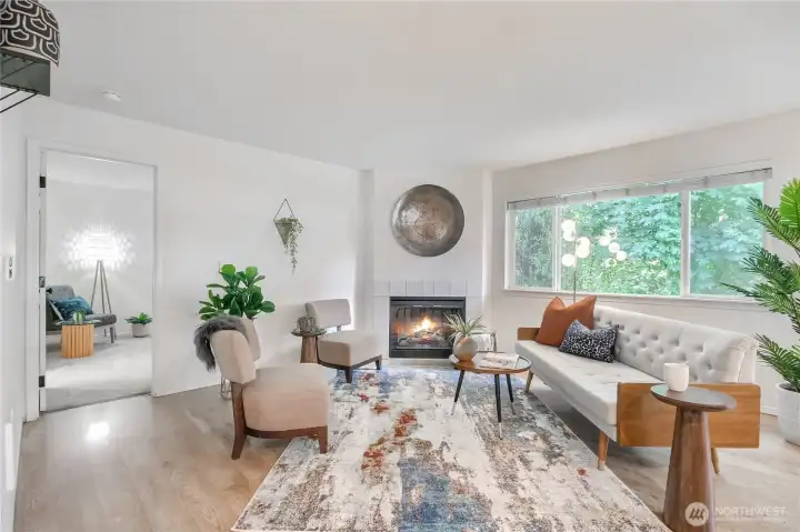 The inviting open floor plan creates a seamless flow between the living, dining and kitchen area, highlighted by a cozy fireplace that serves as the perfect focal point for gatherings.