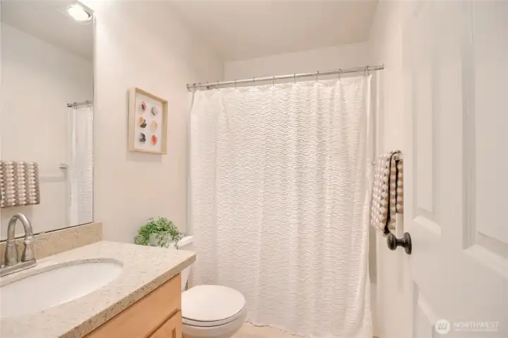 Full bathroom with granite countertops and   brushed stainless steel faucet.
