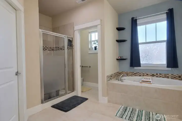 Shower in primary bathroom. Door to left is large walk-in closet.