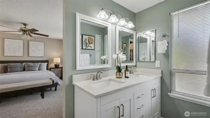 Primary bathroom has quartz counters and tile shower.