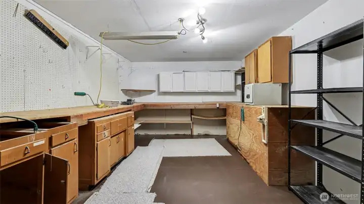 Shop is located behind the garage stalls complete with workbench, peg board, and storage.