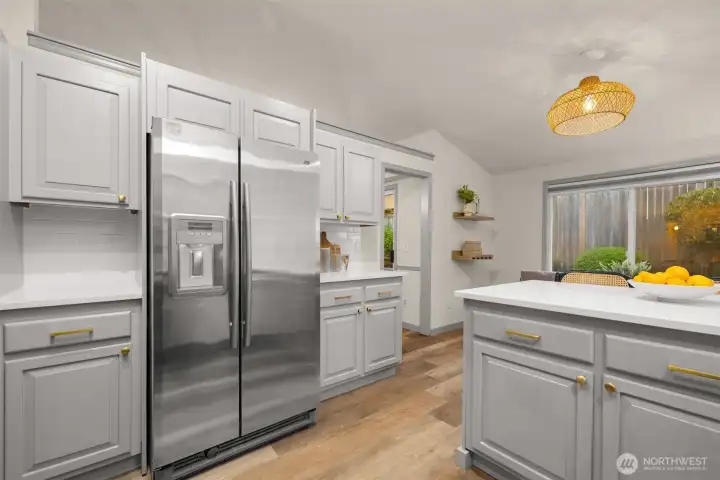 Updated kitchen with quartz counters, fresh paint, new hardware, and new light fixtures.