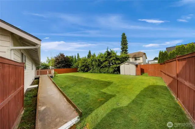 Side yard with outbuilding that has its own private fenced area