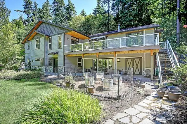 Outdoor living space on deck and covered patio. Perfect space for your hot tub with half bath located off the adjoining rec room. Private garden space encircled by fruit trees and flowering plants. Spacious Workshop with shelf-lined walls is found behind the barn doors. Separate entrance to attached ADU apartment for guests or service provider.