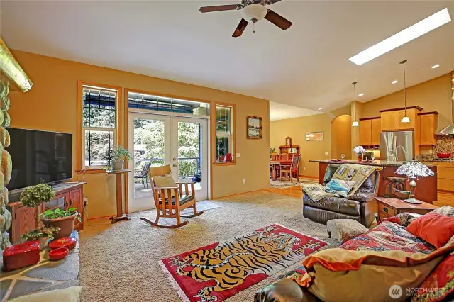 Open concept Great room, kitchen and dining room are Flooded with natural light from skylight in the vaulted ceiling and French doors from both Living and dining areas that open onto outdoor living and dining on the composite planked deck. Perfect for entertaining friends and family and taking in glowing sunsets.