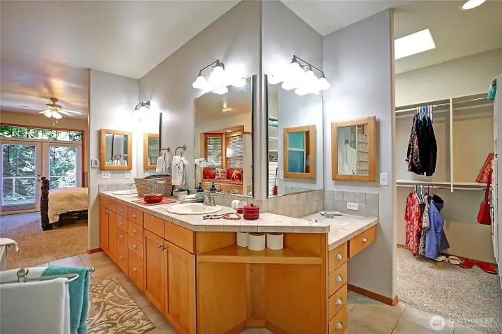 Primary Bath wraps around to a vanity-boudoir space and dressing room with custom built closet to organize your wardrobe and accessories. Skylight bathes the space in natural light.