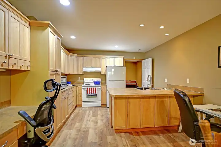 Apartment’s interior entrance into kitchen. Office space with built-in desk. Peninsula breakfast bar and additional prep and dining space. Great cutting table for quilter or hobbyist.