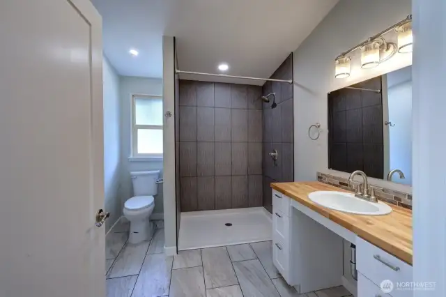 Handicap accessible bathroom with roll in shower.