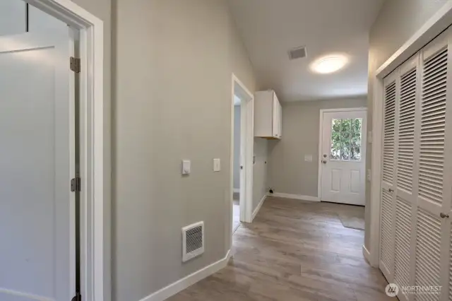 Plenty of room in this laundry located centrally to the bedrooms, bathroom and back door with handicap ramp. The doorways go to the primary suite and bedroom #2.